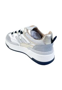Sneaker met een ontwerp in wit, grijs en metallic zilver. Voorzien van een gestructureerde bovenkant, zwarte veters en een gevoerde zool met een marineblauwe accent.