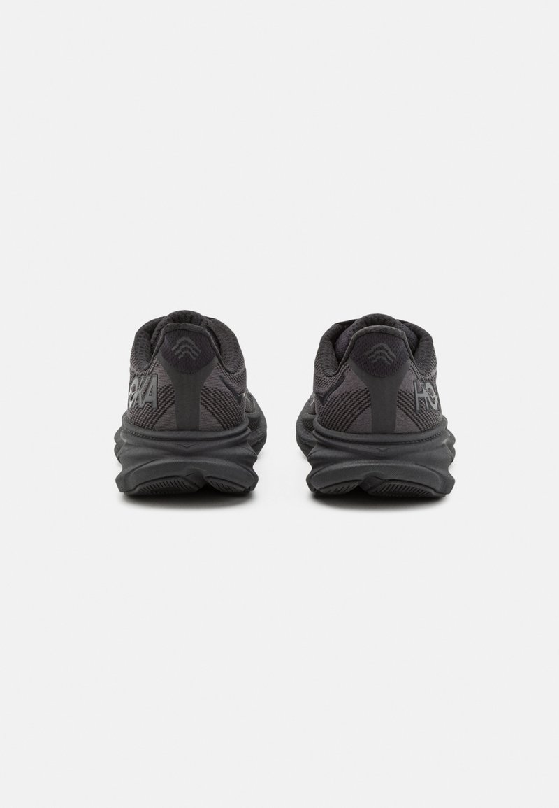 Schwarze Sportschuhe mit einem strukturierten Mesh-Obermaterial, gepolstertem Schaft und dämpfender Sohle. Die Rückansicht zeigt ein markantes Logo und ein geschichtetes Sohlendesign.