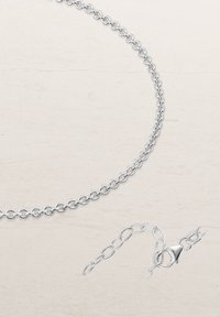 Silver chain necklace with round links, featuring a lobster clasp and extension chain for adjustable length. Smooth, polished finish.