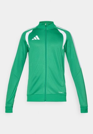 Grøn atletisk jakke med hvide accenter, høj krave, fuld lynlås foran og lange ærmer. Indeholder Adidas-logo og åndbart materiale.