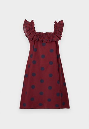 Robe sans manches bordeaux à pois bleu marine, avec bretelles et encolure volantées sur fond uni.