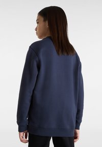 Felpa blu navy con colletto a giro, maniche lunghe e vestibilità rilassata, realizzata in morbido tessuto con polsini e orlo a costine.