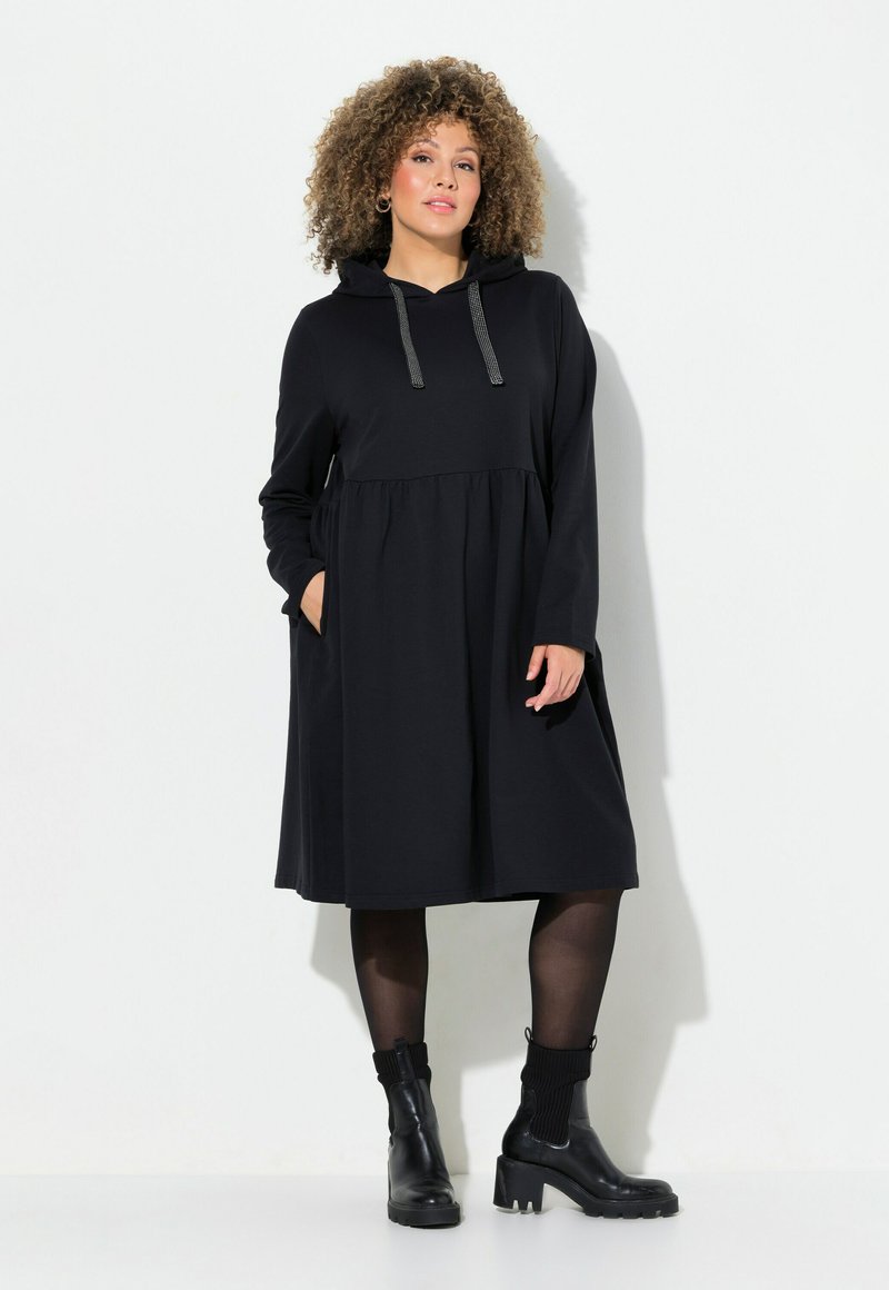 Schwarzes kapuzenkleid mit geraffter Taille, langen Ärmeln und seitlichen Taschen. Hergestellt aus weichem Stoff mit glatter Textur und silbernen Kordelzügen.