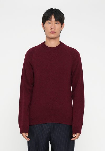 Bourgogne crewneck sweater med lange ærmer, tekstureret strik, og ribbede manchetter og kant, parret med mørke stripede bukser.