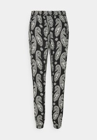 Pantalon noir avec un motif paisley blanc contrastant et des accents floraux. Taille élastique et bas de jambe fuselés. En coton.