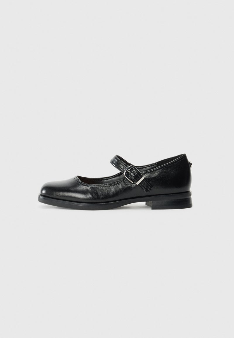 Black leather Mary Jane shoe with a silver buckle strap and low heel, shown from the side on a plain white background.