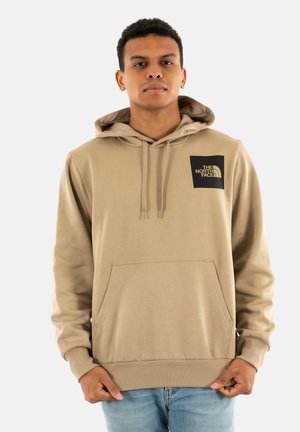 Felpa beige con cappuccio regolabile, tasca a marsupio e polsini a coste. Presenta una patch con logo nero sulla parte superiore sinistra del petto. Materiale morbido.