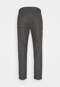 Pantalones de cuadros grises a medida con dobladillos enrollados, bolsillos traseros y presillas para cinturón, mostrados desde la parte posterior sobre un fondo claro y liso.