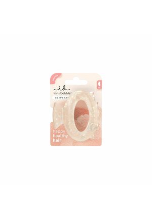 Heldere, ovale haarclip met een textuur aan het oppervlak, gemaakt van duurzaam plastic. Verpakt in een roze-witte kaart met de tekst "happy healthy hair".