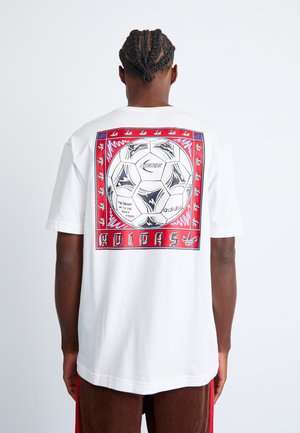 White cotton t-shirt with a graphic print on the back featuring a soccer ball and colorful border details. Short sleeves; relaxed fit.