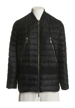 Chaqueta bomber negra acolchada con cremallera frontal y dos bolsillos diagonales con cremallera en un torso de maniquí blanco.