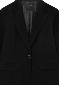 Black blazer made from a textured fabric with a single button closure, notched lapels, and two front pockets. Interior lined with pinstripes.