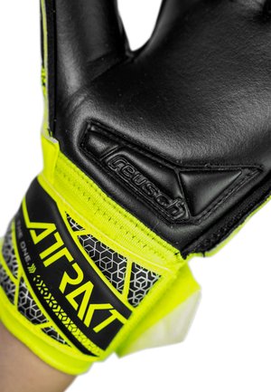 Schwarzer und neongelber Torwarthandschuh mit „Reusch“-Logo und „Attrakt“-Beschriftung am Handgelenkriemen, getragen an der linken Hand.