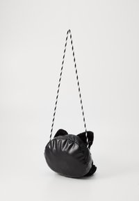 Borsa rotonda nera con una finitura in pelle soffice, caratterizzata da dettagli testurizzati neri e una tracolla attorcigliata bianca e nera.