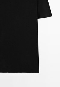 Sort kortærmet t-shirt lavet af blødt, glat stof. Har en afslappet pasform med en lige underkant. Ingen mønstre eller pynt er synlige.