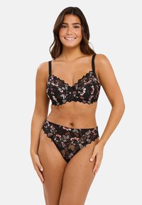 Ensemble de lingerie en dentelle noire avec des motifs floraux en rose et crème, bordé de festons sur le soutien-gorge et le slip assorti.