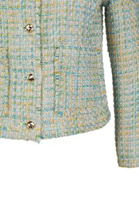 Hellblaues Tweed-Jacket mit gelben und grünen Fäden, ausgestattet mit goldenen Knöpfen, einer aufgesetzten Tasche und fransigen Kanten. Strukturiertes Design.