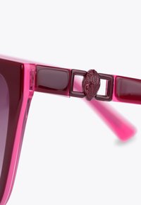 Occhiali da sole trasparenti rosa con lenti quadrate solide e dettagli in burgundy testurizzato sulle astine, comprese un elemento hardware dettagliato.