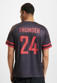 Tmavošedý dres s červenými akcentmi, na chrbte s nápisom "THUNDER" a číslom "24". Krátke rukávy so pruhovaným vzorom. Ľahký materiál.