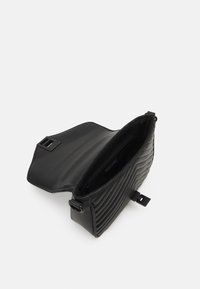 Borsa a tracolla nera trapuntata con superficie testurizzata, chiusura a patta e tasca interna; realizzata in materiale sintetico con finitura liscia.