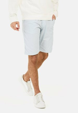 Light blue shorts with a lightweight fabric, a relaxed fit, and side pockets, paired with white sneakers and a cream sweatshirt.