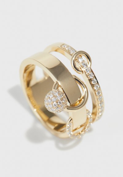 Gold ring featuring intertwined bands, a smooth surface, and a spherical accent encrusted with clear rhinestones along one edge.