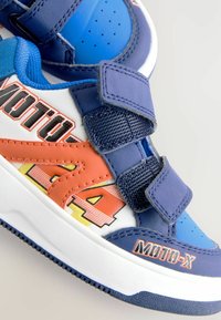 Børns blå, orange og hvide sneakers med velcrostropper og "MOTO-X" branding på siderne og tæenområdet.