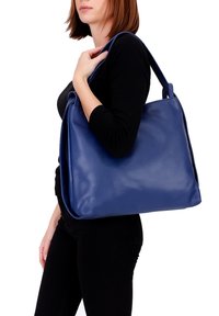 Grote blauwe leren handtas met een gladde textuur, rechthoekige vorm en dubbele draagriemen, gepresenteerd tegen een effen witte achtergrond.