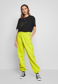 Nike Sportswear W NSW ESSNTL PANT FLC TREND - Calças de fato de treino - bright cactus/(white)