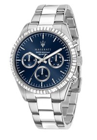 Silverfärgad klocka i rostfritt stål med en blå urtavla, tre sub-dials, upphöjda timmarkeringar och en texturerad krona. Vattentålig upp till 100 meter.