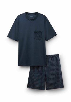 Chemise à manches courtes bleu marine avec une poche à pois, assortie à un short bleu marine présentant un motif de pois blanc.