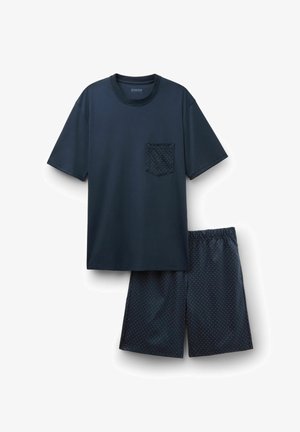 Chemise à manches courtes bleu marine avec une poche à pois, assortie à un short bleu marine présentant un motif de pois blanc.