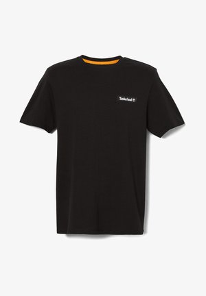 Black cotton t-shirt with short sleeves, round neck, and orange accent at neck. Features a white logo patch on the left chest.