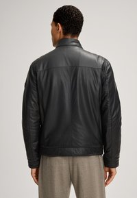 Schwarze Lederjacke mit glatter Textur, standardmäßigem Kragen und taillierter Passform. Verfügt über Schulternaht und einen geraden Saum.