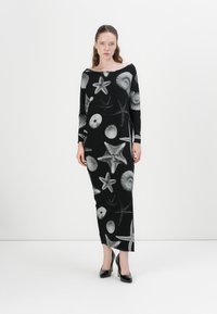 Schwarzes, langärmeliges Kleid mit taillierter Silhouette, das mit einem Muster aus weißen Muscheln und Seesternen verziert ist, aus einem weichen, strukturierten Stoff gefertigt.