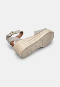 Beige suede platvormsandale laia rihmaga, ringikujulise pandlaga ning tekstureeritud, soonilise tallaga, mis tagab parema haarde.