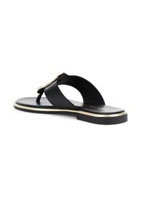 Mustat flip-flop-sandaalit kultasävyisellä yksityiskohdalla, joissa on sileä tasapohja, avonaiset varpaat ja selkäpuoli auki.