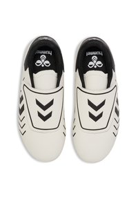 White slip-on sports shoes with black chevron patterns and black interior lining, viewed from above.