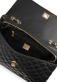 Borsa a tracolla in pelle trapuntata nera con una cerniera dorata, dettagli in catena e un motivo. Presenta una tasca interna con cerniera e un quadrato con il logo del marchio.