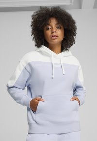 Felpa con cappuccio azzurro chiaro con una sezione superiore bianca, dotata di tasca frontale e dettagli del logo discreti in un colore contrastante.