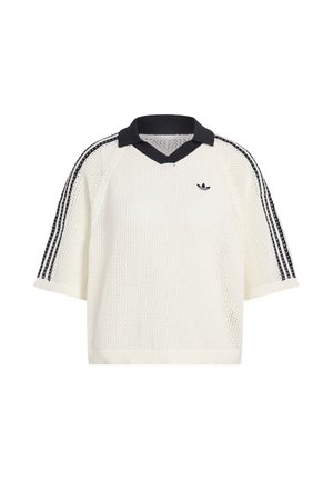 Biely pletený sveter s krátkym rukávom a čiernym rebrovaným golierom, so z troch čiernych pruhov na pleciach. Obsahuje malé logo na hrudi.