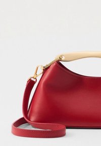 Piros bőrtáska sima felülettel, krémszínű felső fogantyúval és aranyszínű csattal. Állítható pánttal ellátva.