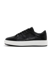 Baskets en cuir noir avec une finition lisse, bout rond, semelle plate en caoutchouc blanc et lacets noirs comportant sept œillets.