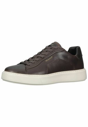 Brune lærersneakers med rund tå, kontrasterende hvit gummisåle, snøring og gulllogo aksent på siden.