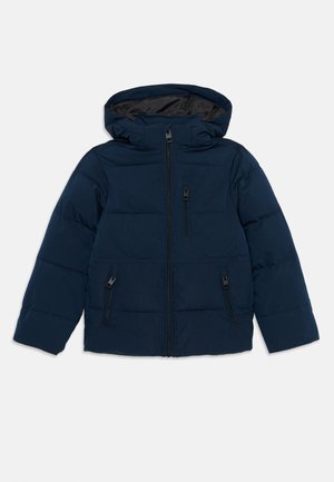 Veste rembourrée bleu marine avec capuche, fermeture éclair à l'avant, deux poches latérales zippées et une poche zippée sur la poitrine, posée à plat sur un fond blanc.