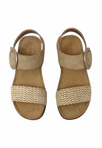 Sandali in pelle beige con una larga fascia intrecciata sulla parte superiore del piede e una fibbia rotonda sulla cinghia alla caviglia. Suola piatta con una legggera texture.