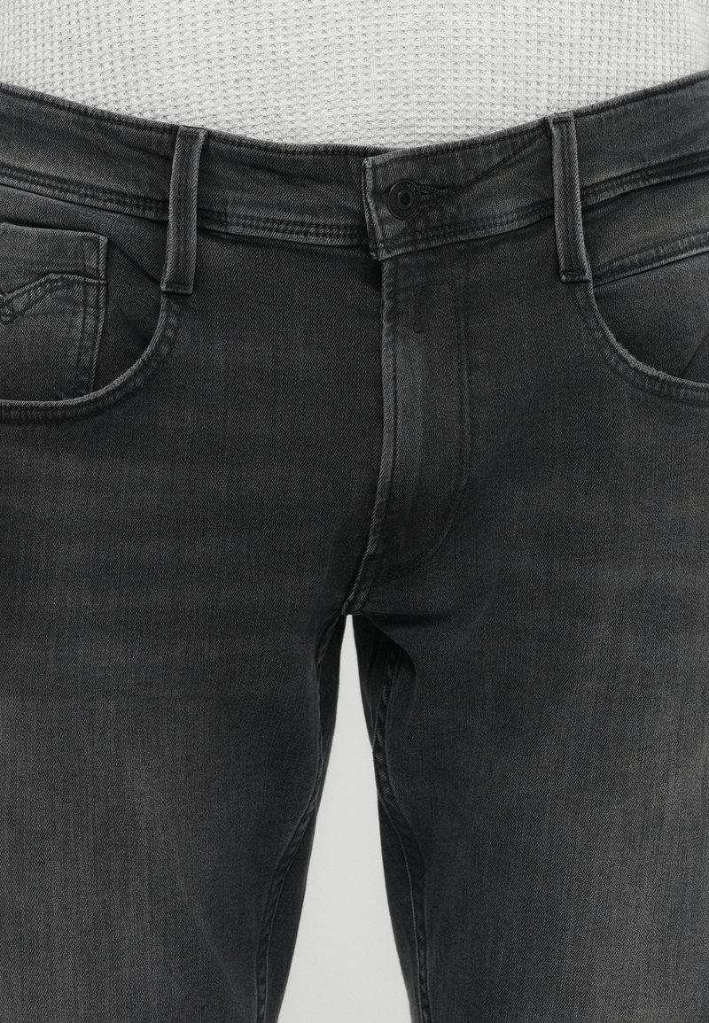 Zwarte denim jeans met een slim fit, voorzien van een knoopsluiting, vijf zakken en subtiele vervaging op de stofstructuur.