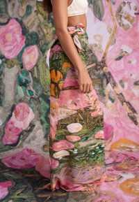 Vzdušná, vzorovaná zavinovací sukně s květinovými motivy v růžových, zelených a oranžových odstínech. Vyrobená z lehké látky, uvazovaná v pase.