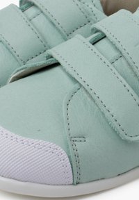 Scarpe in pelle verde chiaro con fasce in Velcro, punta bianca texturizzata e dettagli di cucitura a contrasto. Design arrotondato per il massimo comfort.