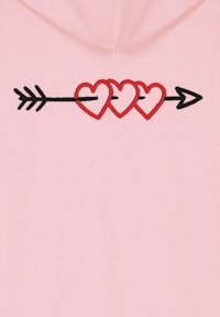 Felpa rosa chiaro con cuciture nere e un design ricamato rosso che mostra tre cuori collegate da una freccia, con un contorno e rifiniture distintive.